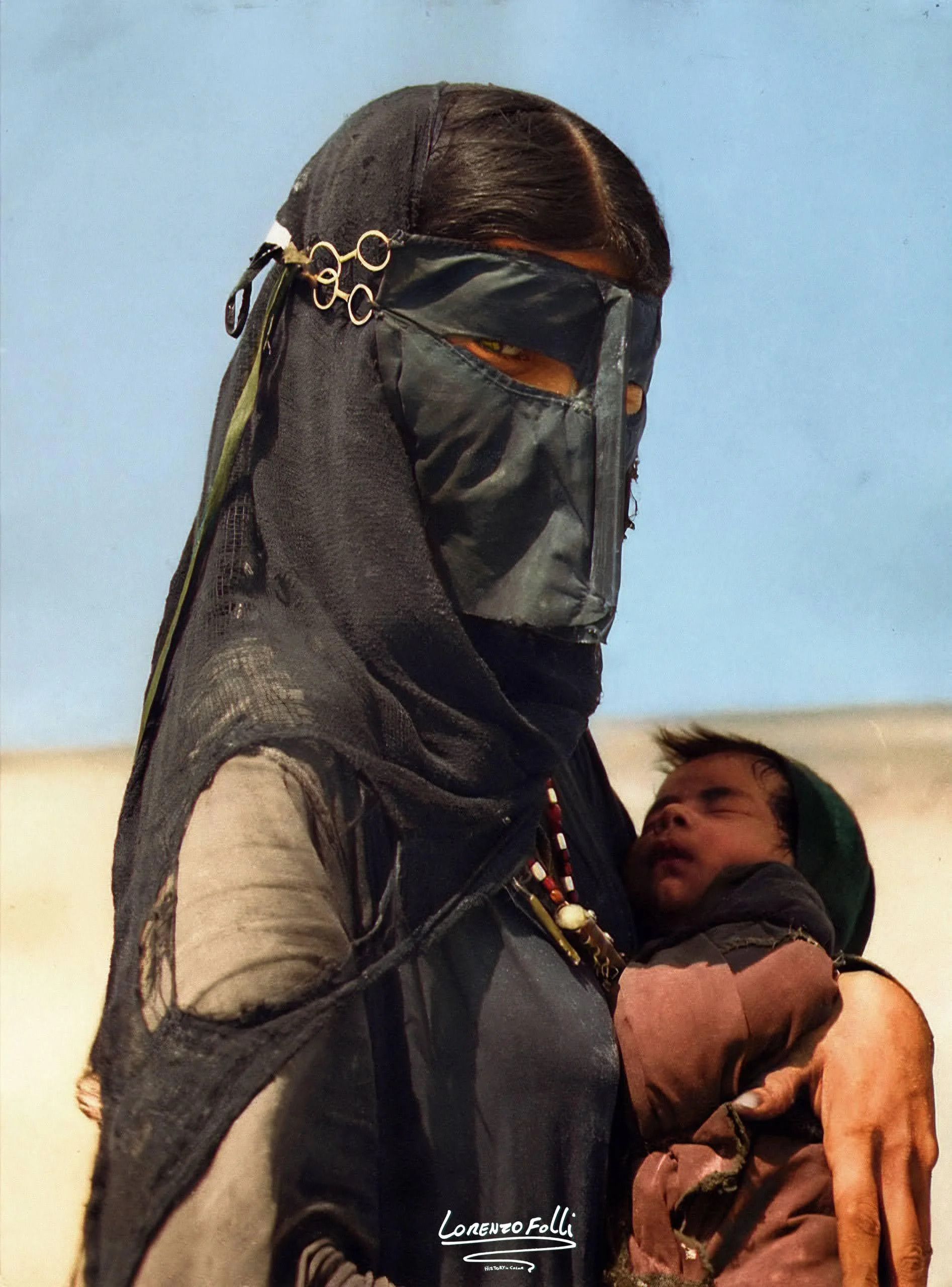 A colorized photo of a bedouin woman and her baby by Lorenzo Folli